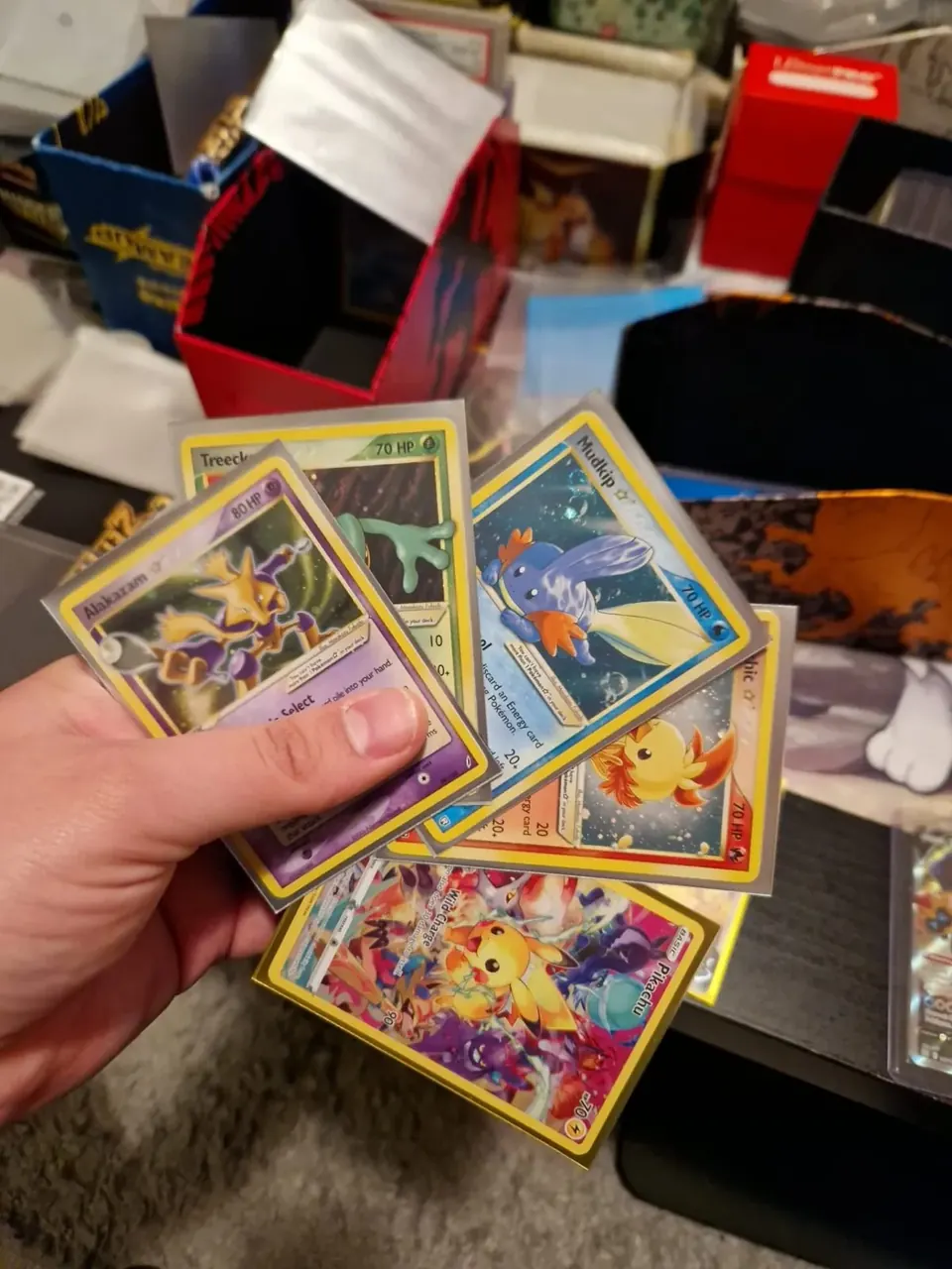 Gold Star Pokémon karte držane u ruci iznad kolekcije